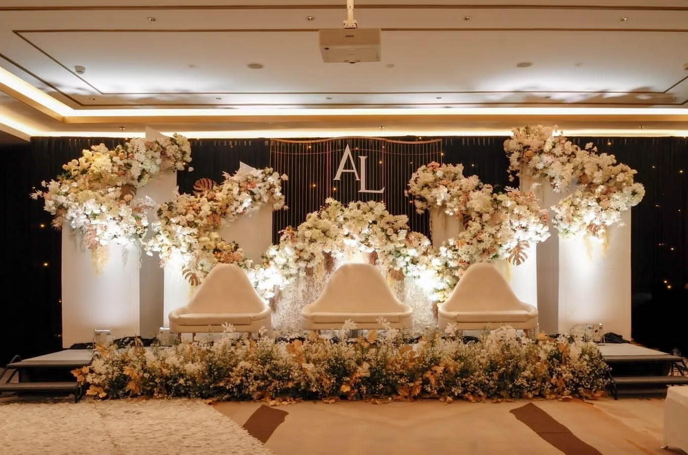 Ivory floral cascade columns with monogram backdrop