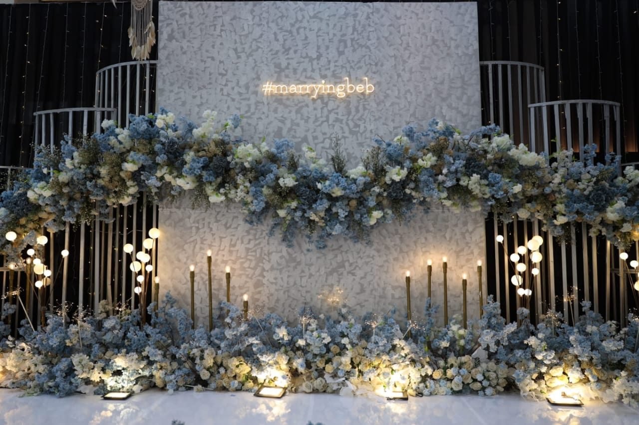 Dusty blue and ivory floral wall with warm candlelight